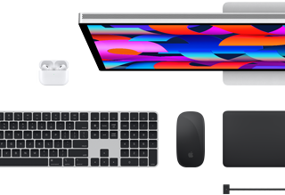 Top view of select Mac accessories: Studio Display, Magic Keyboard, Magic Mouse, Magic Trackpad, AirPods and MagSafe charging cable